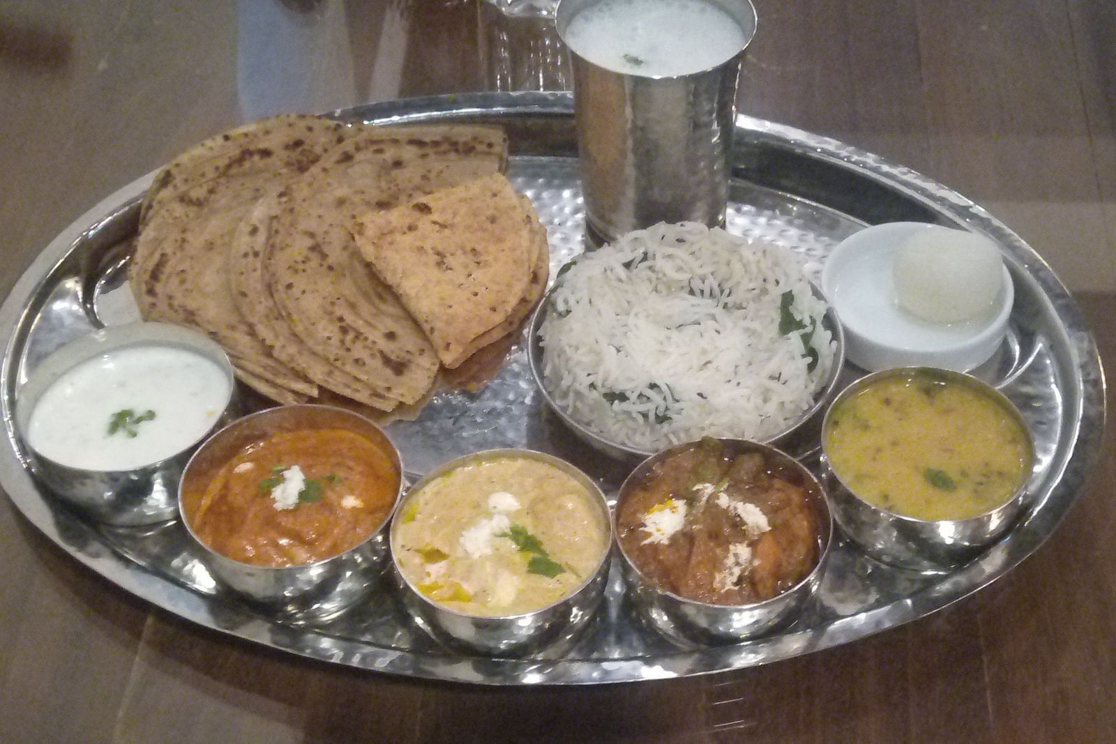 A beautifully arranged Punjabi thali featuring a variety of delicious Indian dishes served at Cafe, Matsya Island Retreat. The vibrant plates include traditional curries, rice, bread, and sides, all set against a serene backdrop of the retreat.