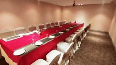 A table set up inside a room with cutlery and glasses for dining inside the coral hall - VITS Bharat Nanded