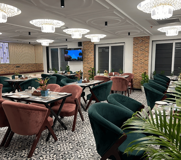 Neatly arranged with velvet chairs and chandeliers at Lime Tree Hotel Near India Expo Mart, Greater Noida.