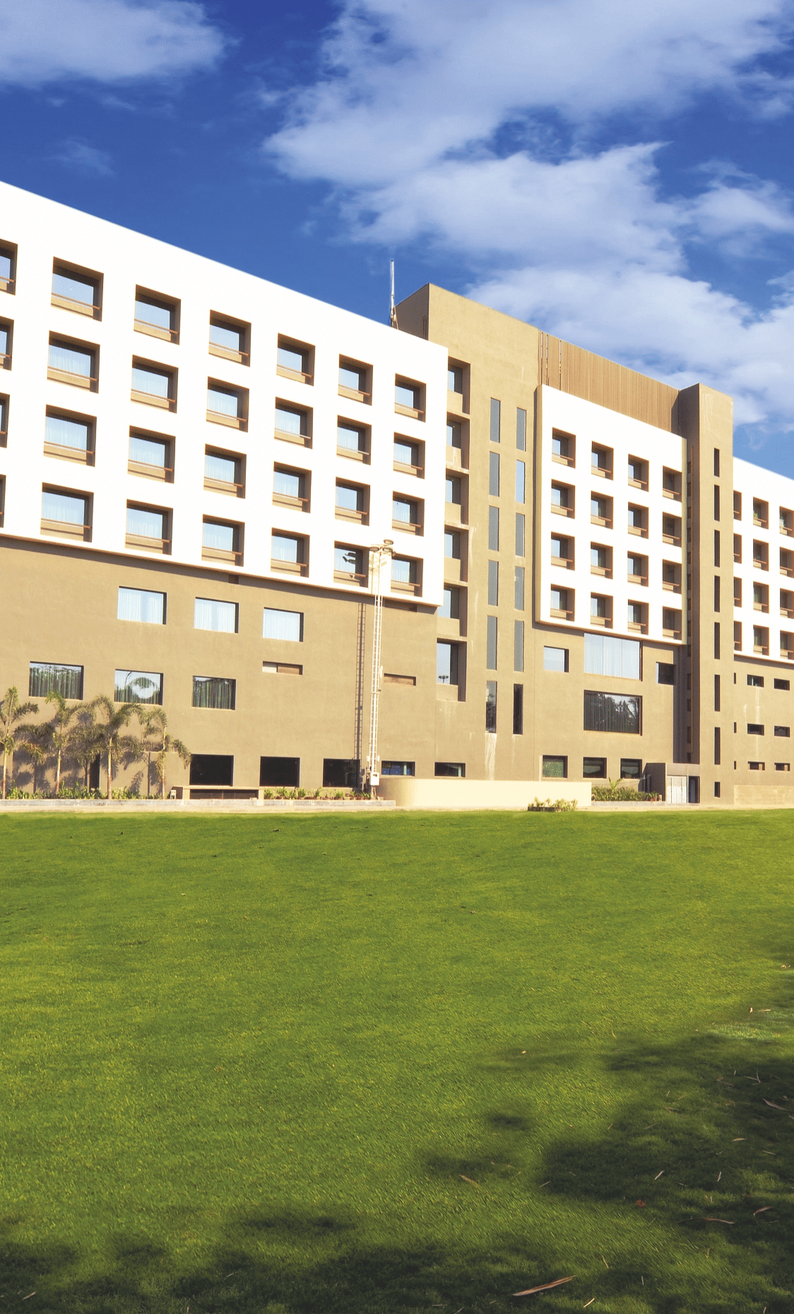 Exterior view of hotel building with expansive lawn – Narayani Heights Hotel & Resorts