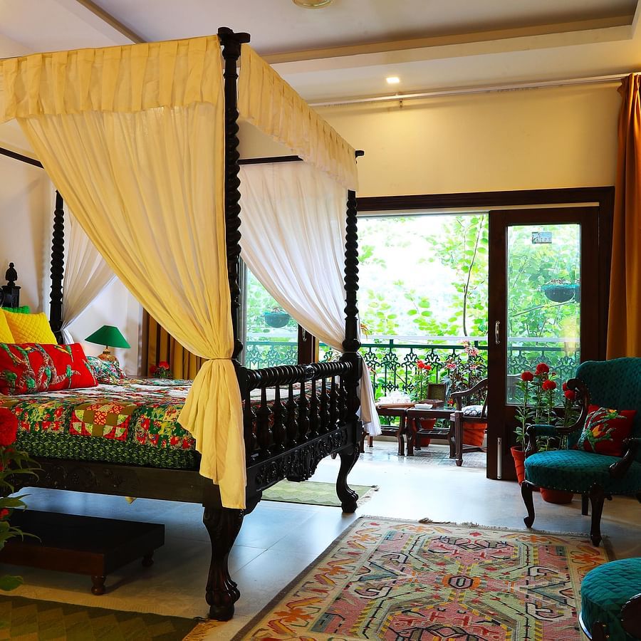 parakreet - A spacious bedroom with a four-poster bed and a view of the outdoors.