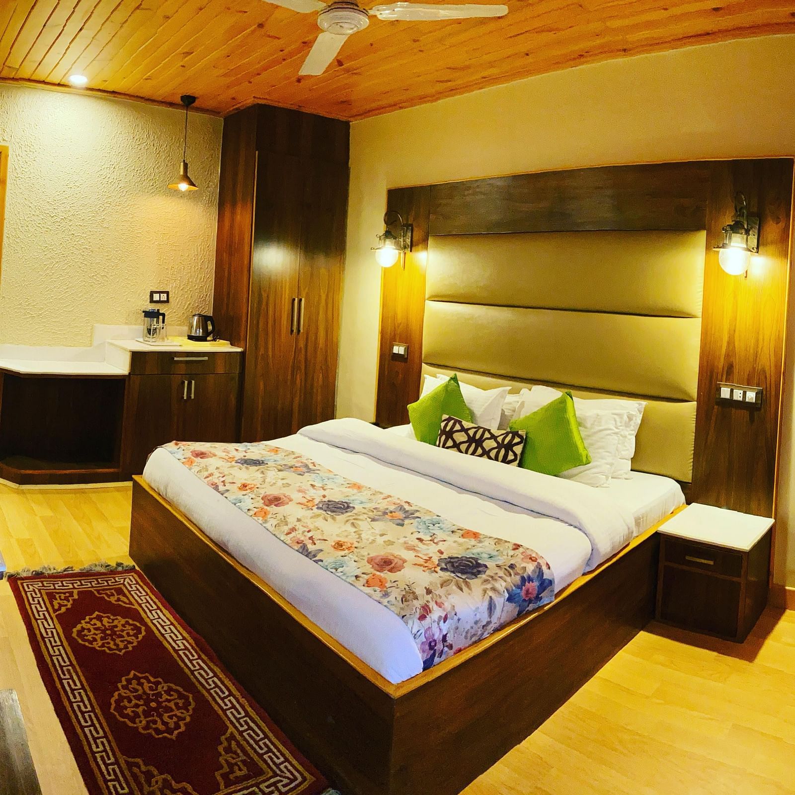 A room with a bed and TV on the wall | Mongas Hotel & Resort, Dalhousie