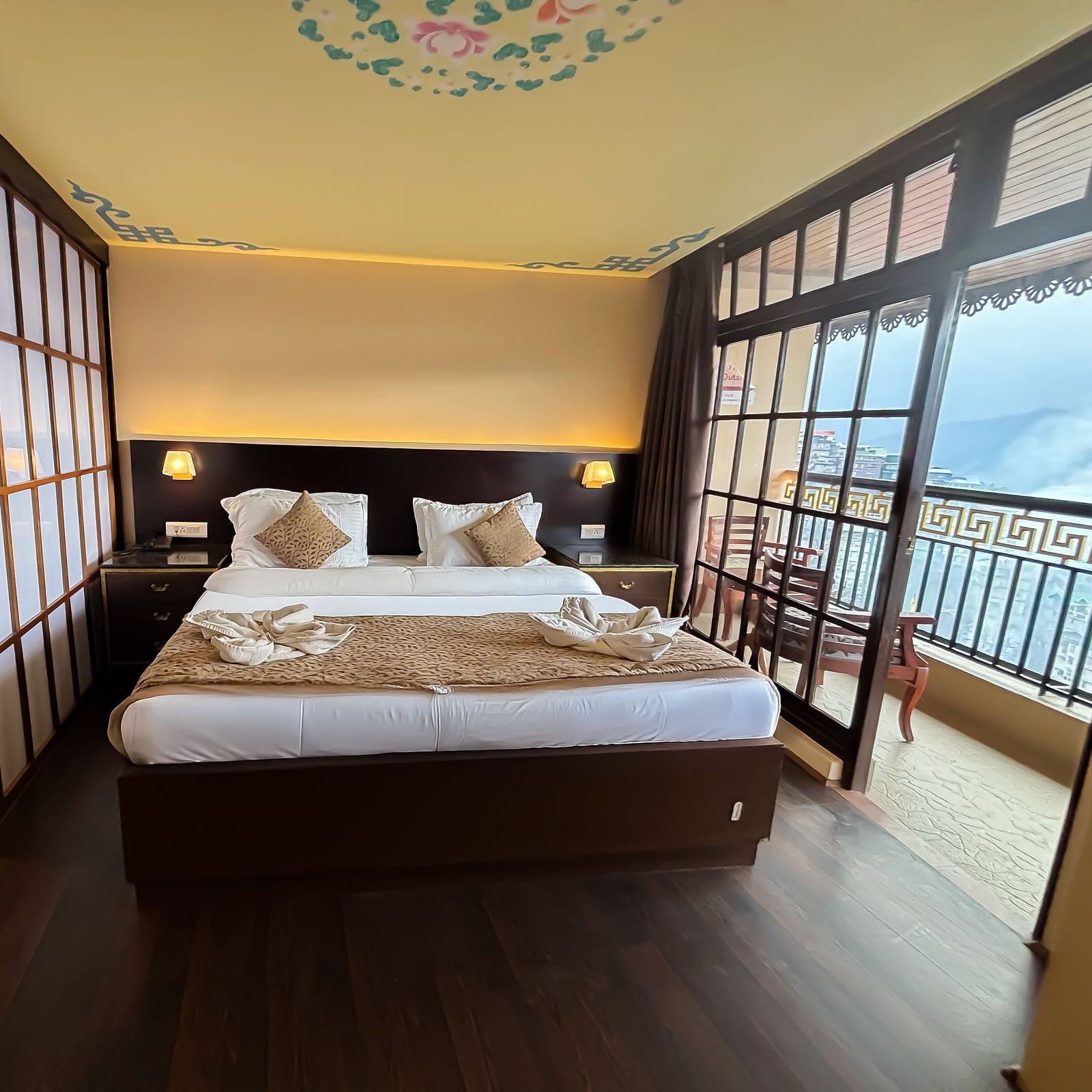 Bedroom with a balcony offering mountain views at Avianna Hungry Jack, Gangtok.