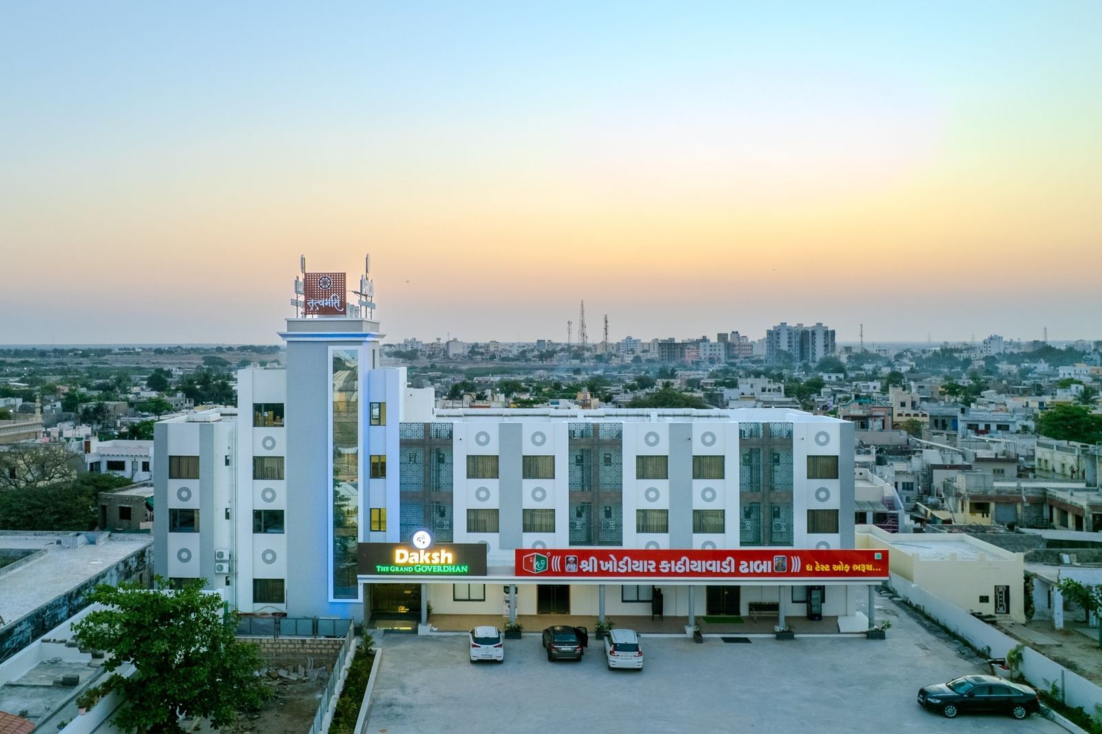 Expansive aerial view of Daksh The Grand Gowardhan, Dwarka, at dusk, revealing its impressive scale amidst the surrounding landscape.