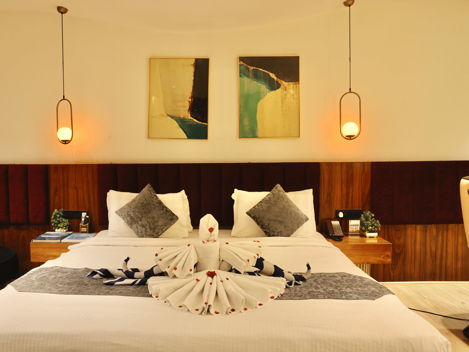 Club Suite, Bed beneath framed art and pendant lights