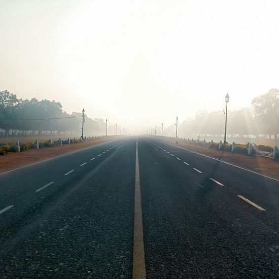 An overview of a road in Delhi with two lanes and mist covering in the background