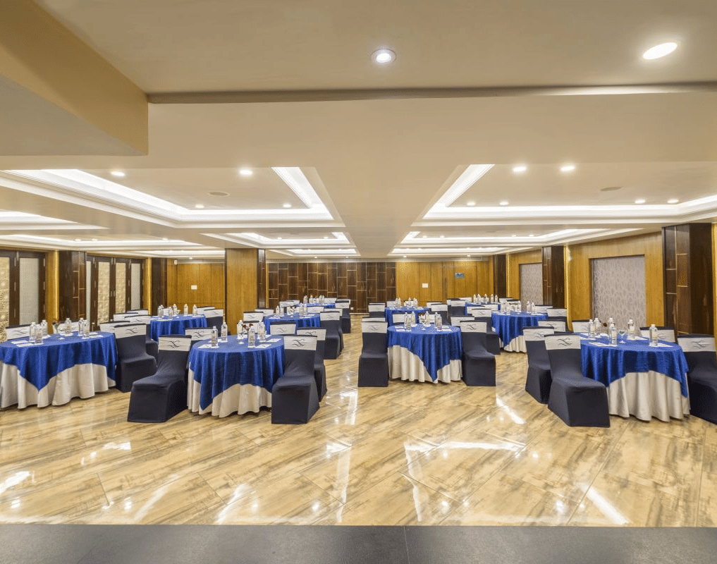 A conference room with round tables, blue tablecloths, and chairs arranged for an event - The Citrine, Bangalore