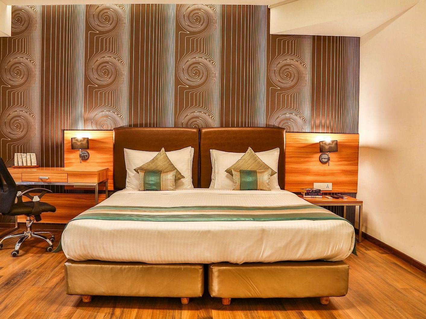 Club Room at T24 Residency, Andheri East (Terminal 2) featuring a double bed in warm lighting with a work desk next to the lamp.