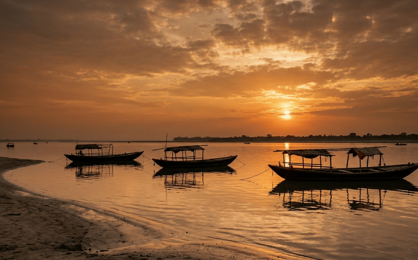 Serene sunset view over Chilika Lake with silhouettes of local fishing boats.