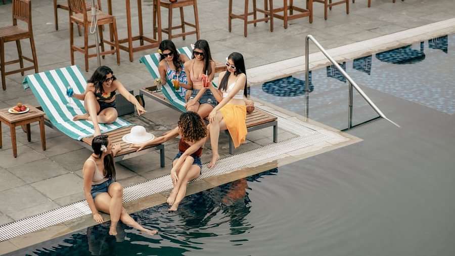 A group of women lounging near the outdoor swimming pool at Singalila Club