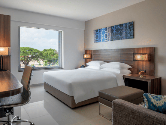 Standard king room featuring a bed, couch, television and a working area at The Residency Towers Rameswaram