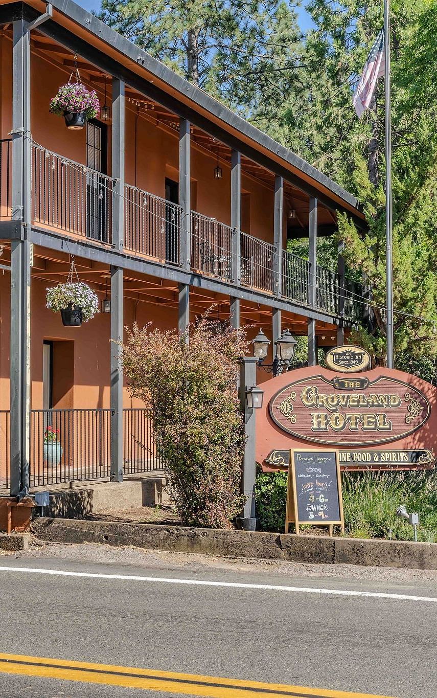 Exterior of a cabin at The Groveland Hotel during the day with the hotel's signage in view.