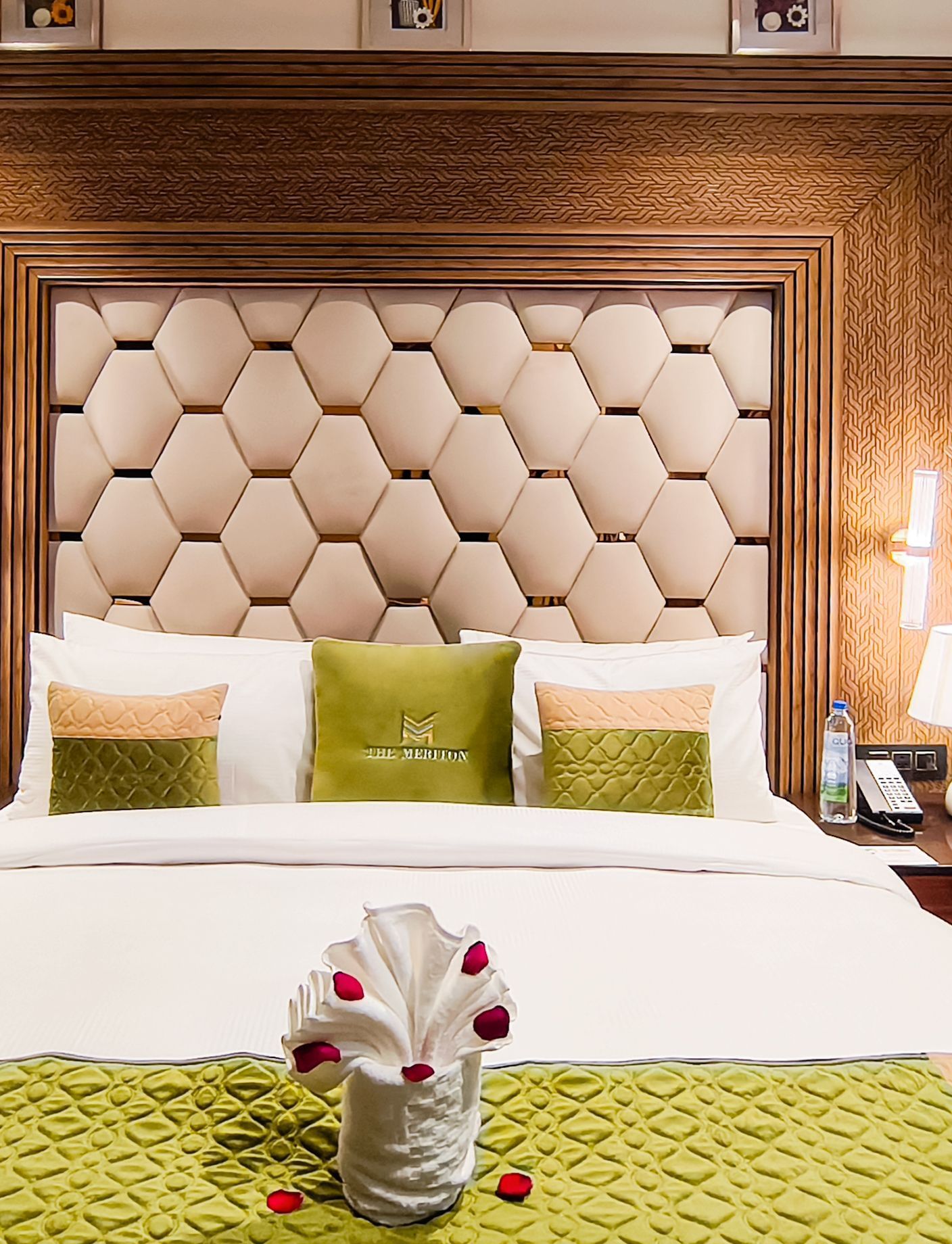 Junior Suite bedroom at The Meriton, New Delhi featuring plush bedding and warm lighting