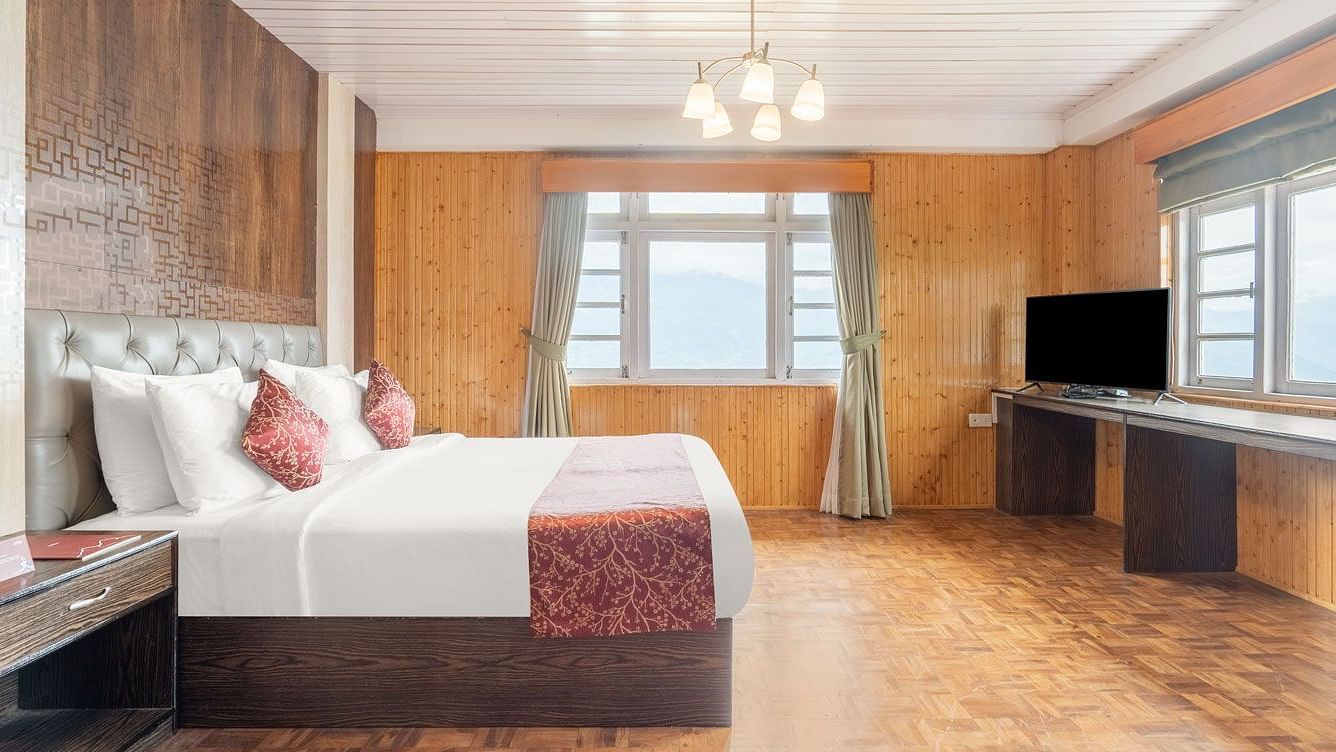 Side view of a room with bed and wooden wall decor at Summit Tashi Ghang Heritage Resort, Pelling