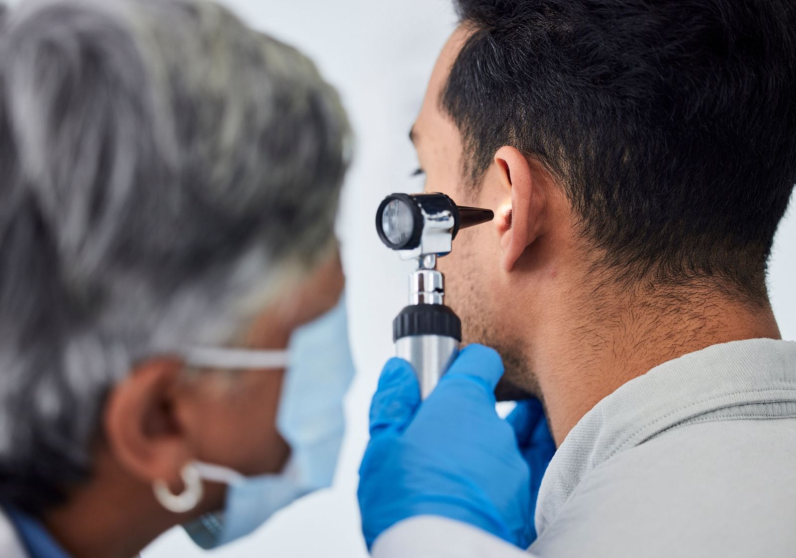 A doctor using an otoscope to examine a patient’s ear - Shreyas Retreat