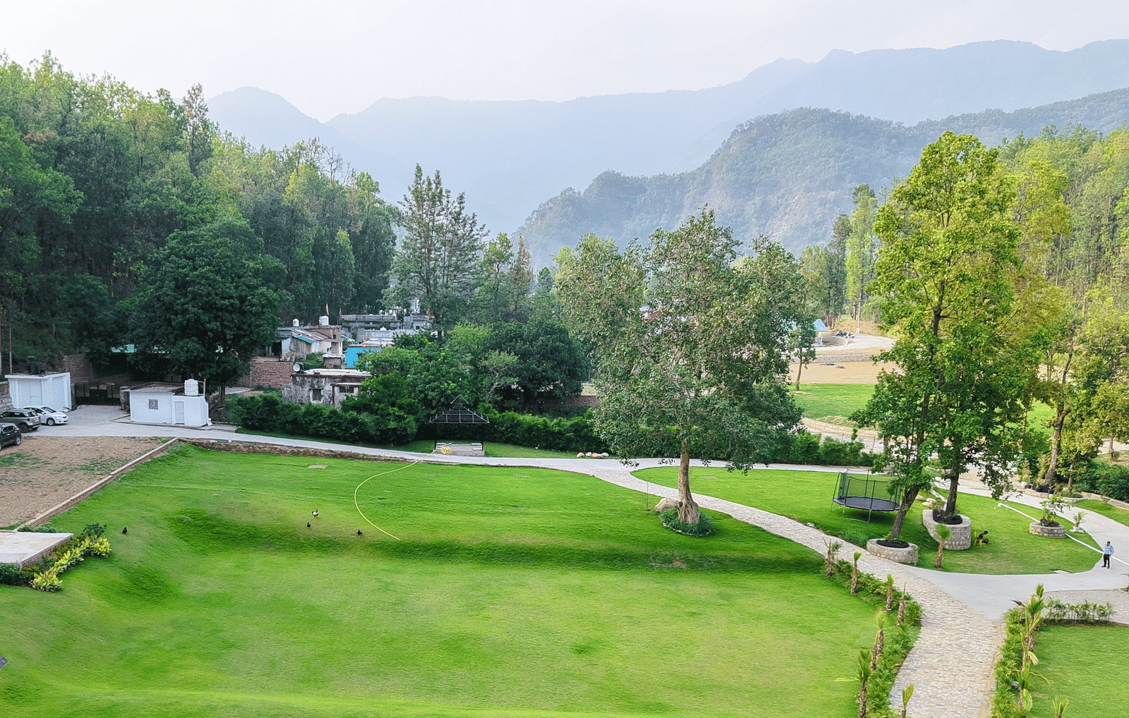 Scenic aerial view of the resort surrounded by lush greenery and distant mountains - Megha Resort & Villas, Dehradun