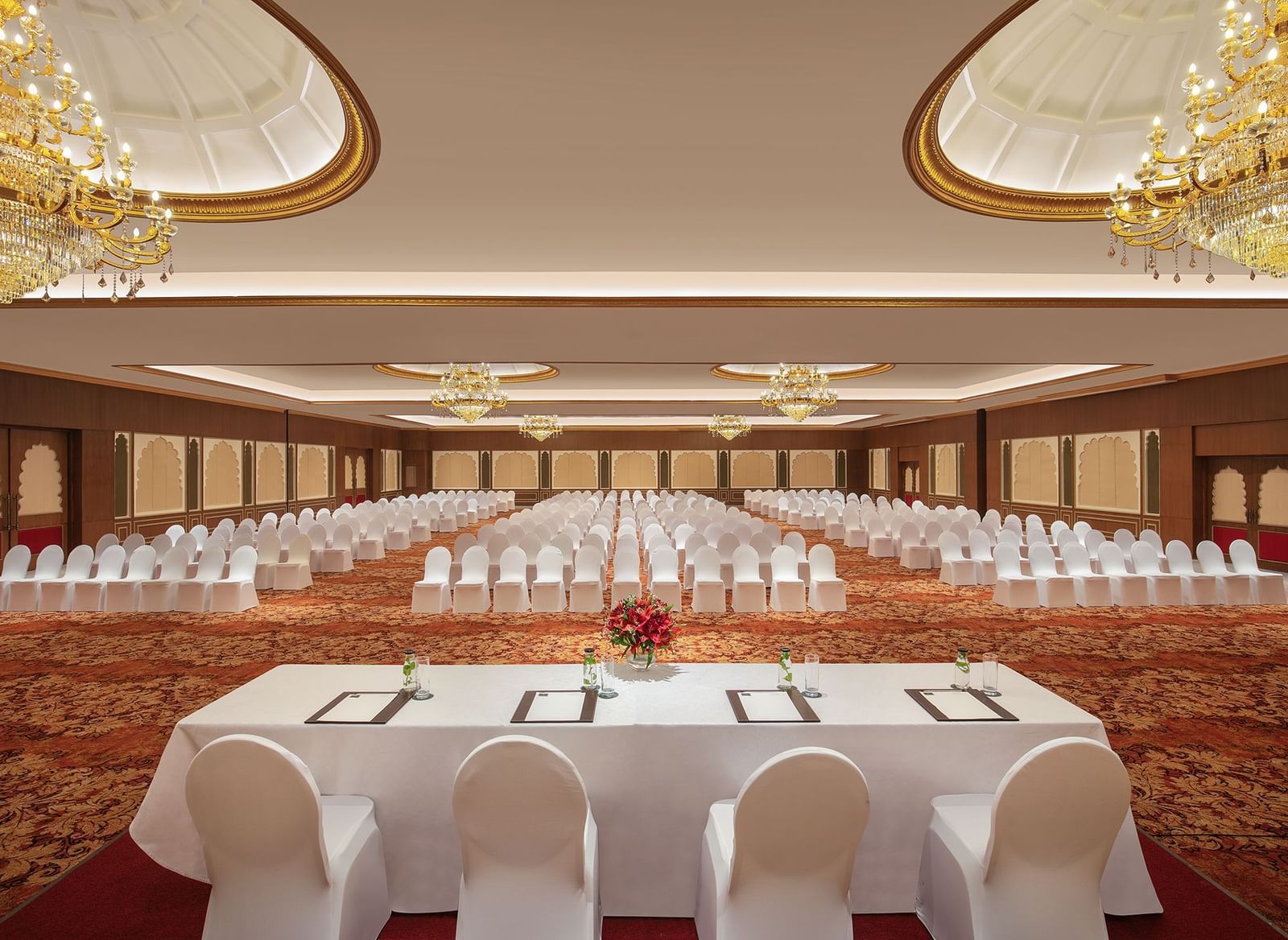An image of a ballroom in Mahablipuram with chandeliers, carpeted floors and chairs arranged in a theatre style arrangement - Kaldan Samudhra Palace