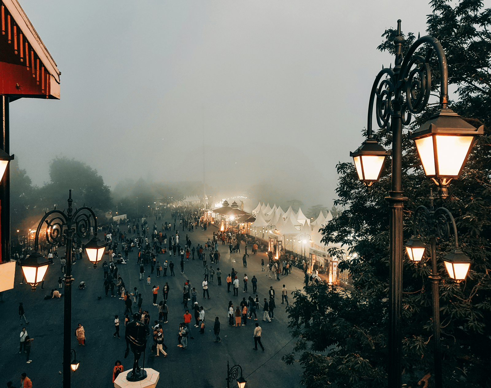Busy street scene with mist and pedestrians, cityscape view.