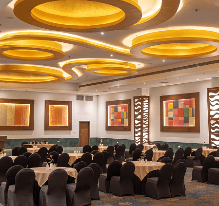 A banquet hall with tables and chairs set for an event. - Bamboo Saa Resort & Spa, Udaipur.