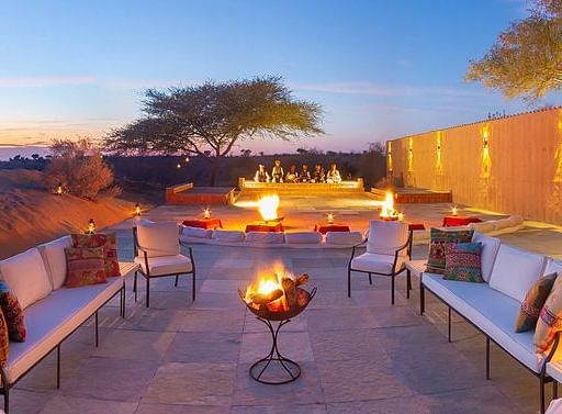 An image of the outdoor seating area with a bonfire in the middle at MANVAR Resort & Desert Camp