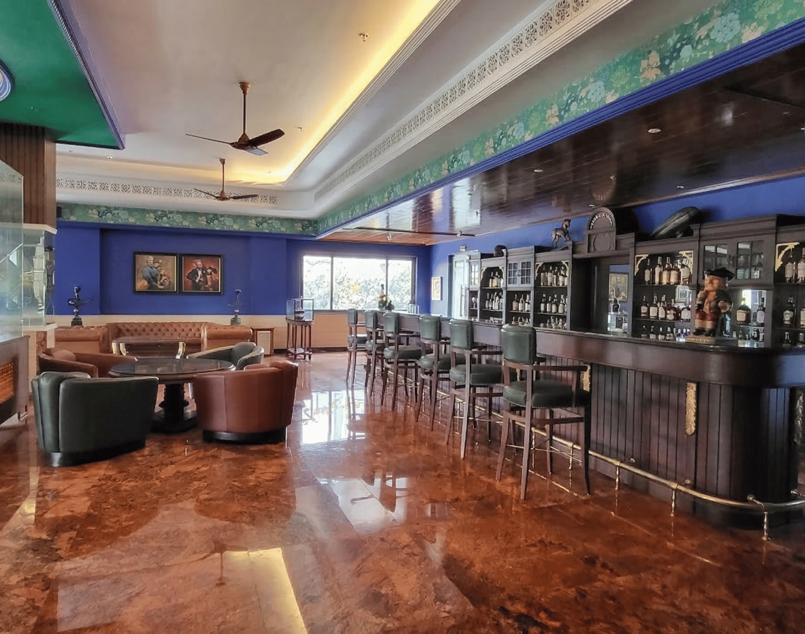 Spacious interior of Captain's Quarter restaurant at MAYFAIR Bay Resort Paradeep, with shiny marble floors, ambient purple lighting, and open dining area