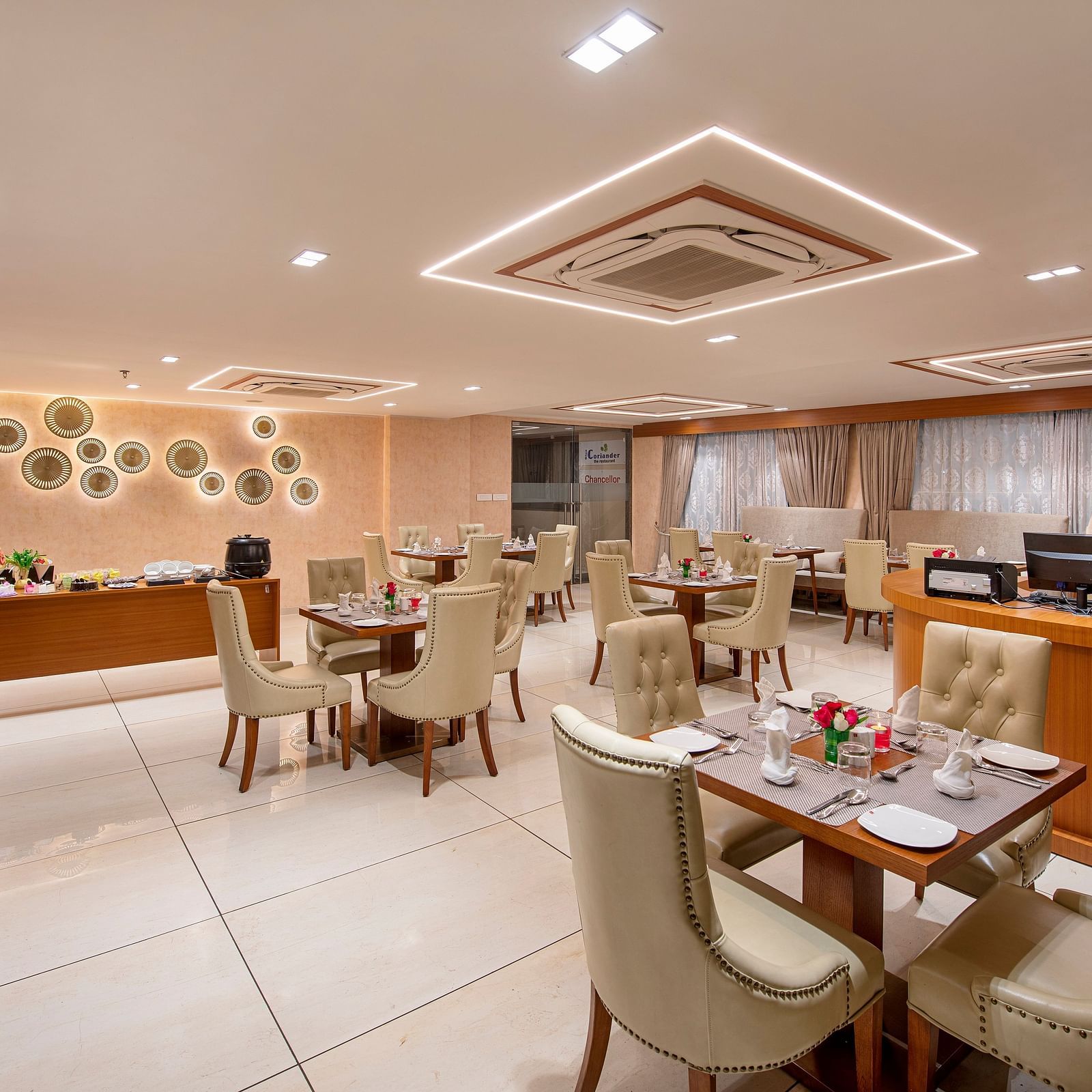 A view of a hotel dining space, showing a mix of table setups - SK Lords Inn Ahmedabad