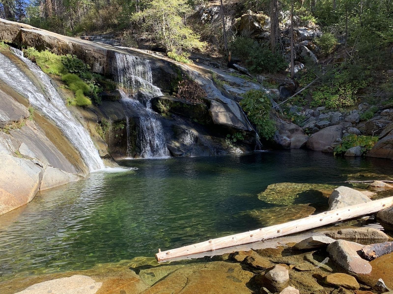 water flowing into a serene pond at Carlon Falls, surrounded by lush trees