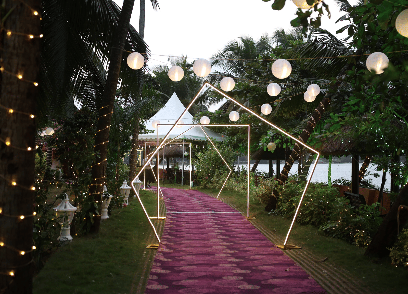 Walkway covered with white canopy and hanging lanterns at Paradise Lagoon Resort, Udupi.