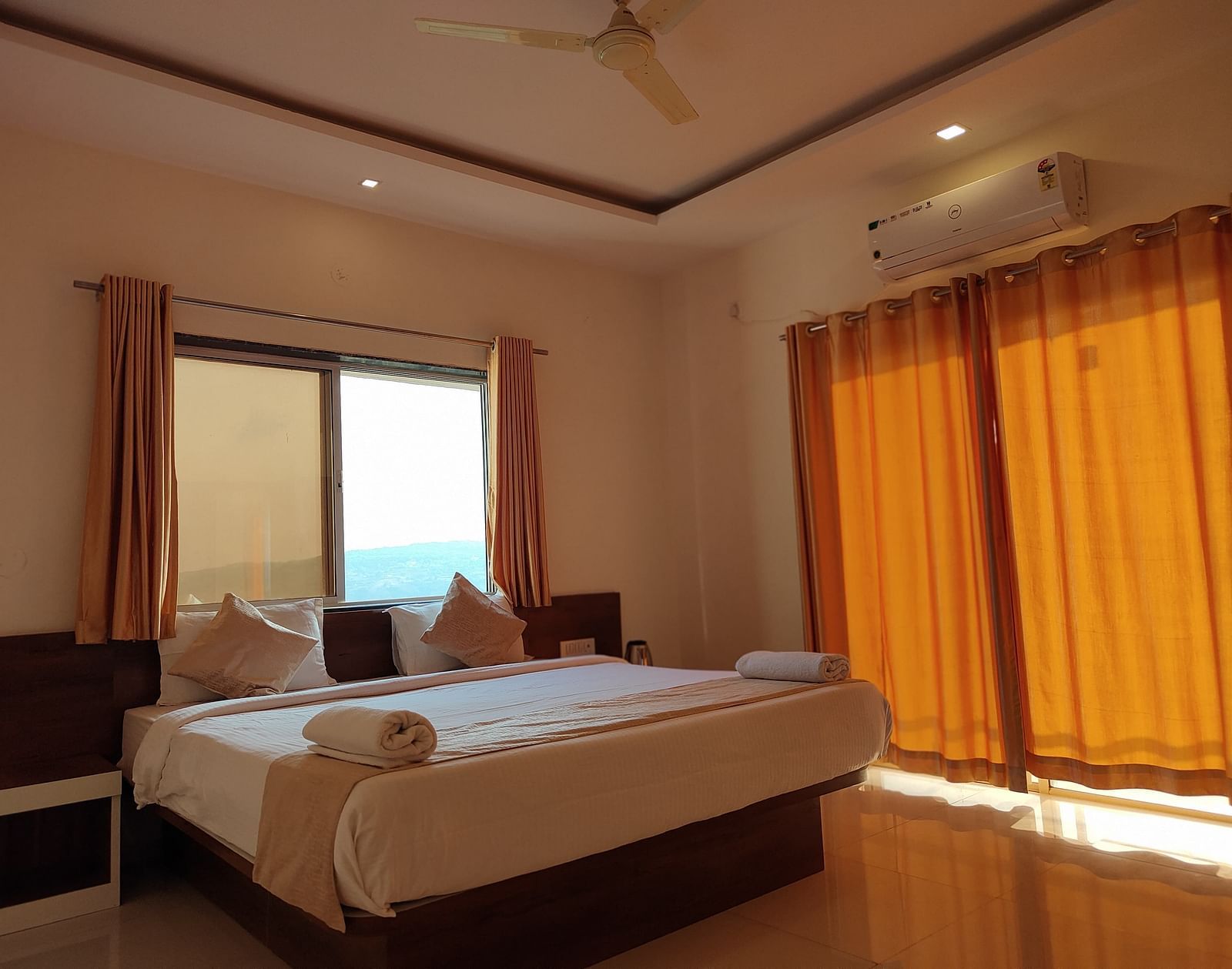 Superior Valley View Room with a large bed, orange curtains, and a window with a view.