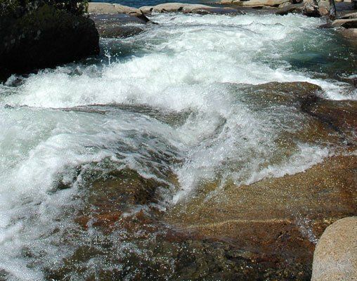 A close-up view of rushing water cascading over rocks in a stream or river
