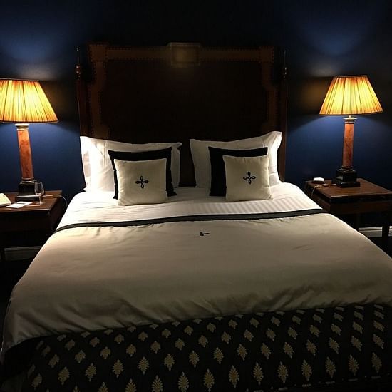 A front view of bed with two night lamps on either sides
