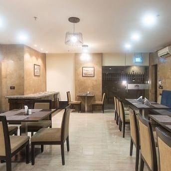 Chairs and round tables at a restaurant | Hotel Mumbai House, Andheri East