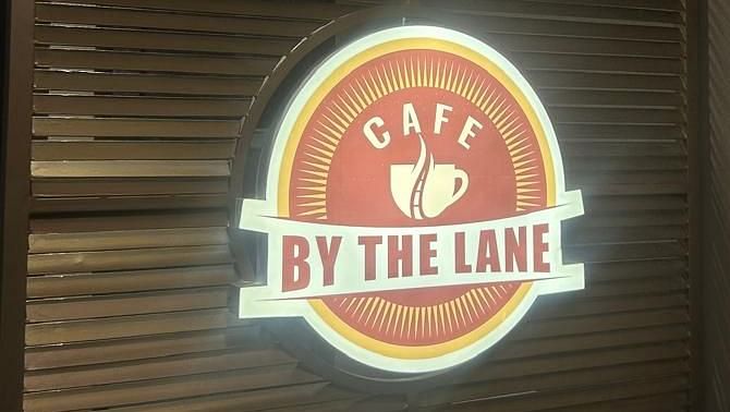 A close-up of a wooden door with the OnTime Hotel logo at The OnTime Hotel, Bangalore.