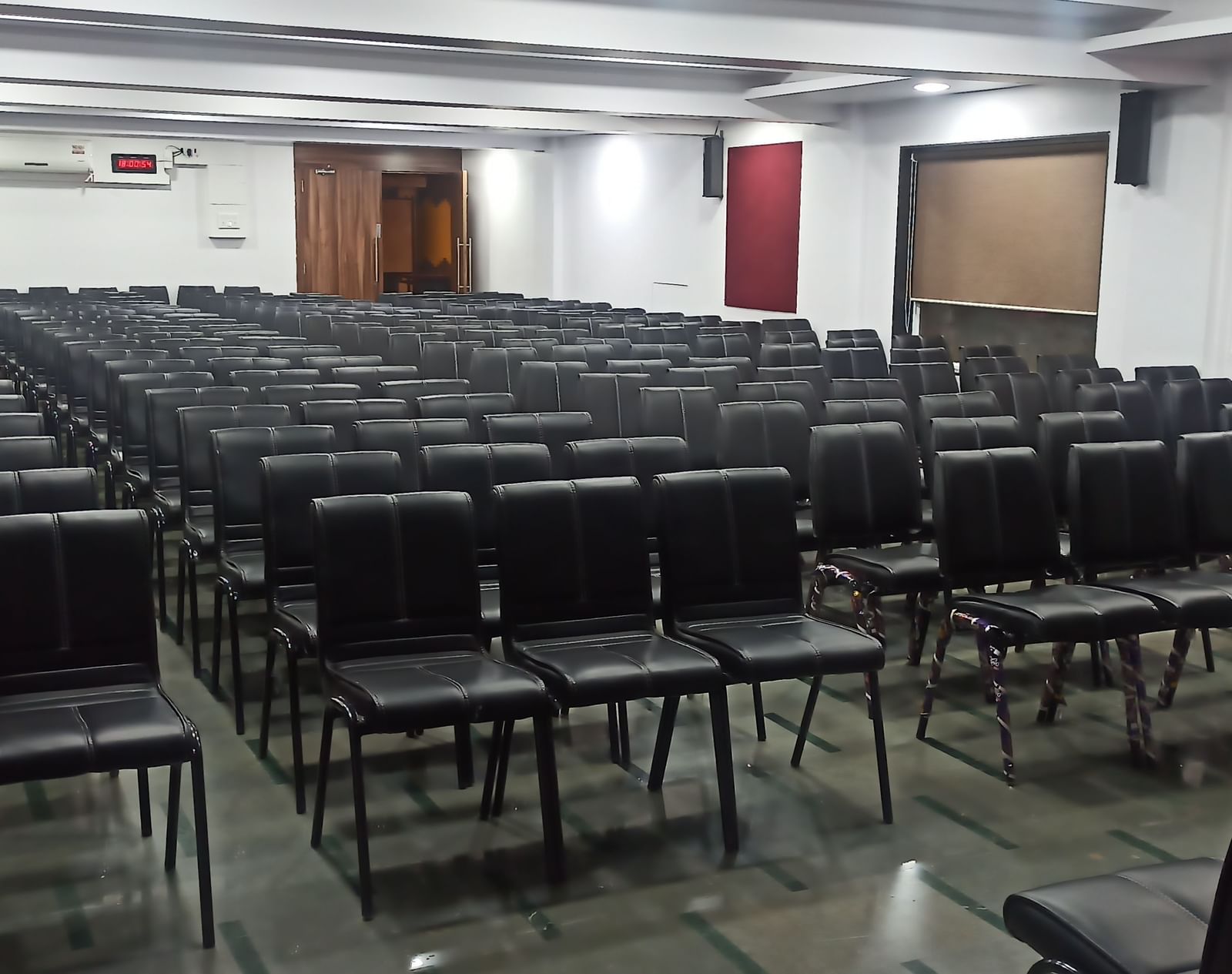 Theatre style seating arrangement with rows of black chairs in a rectangular hall at Mayur Retreat.