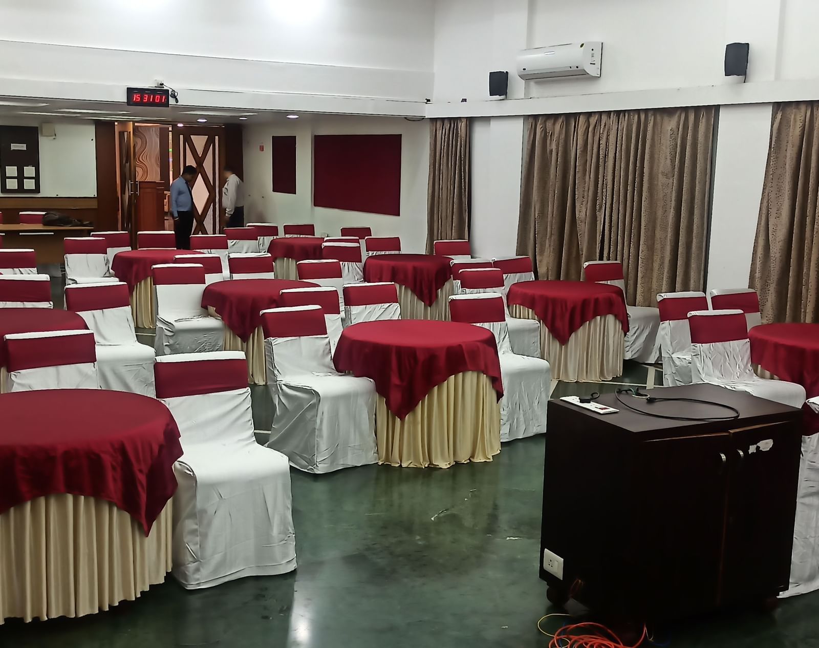 Cluster seating arrangement with multiple round tables and cushioned chairs at Mayur Retreat.