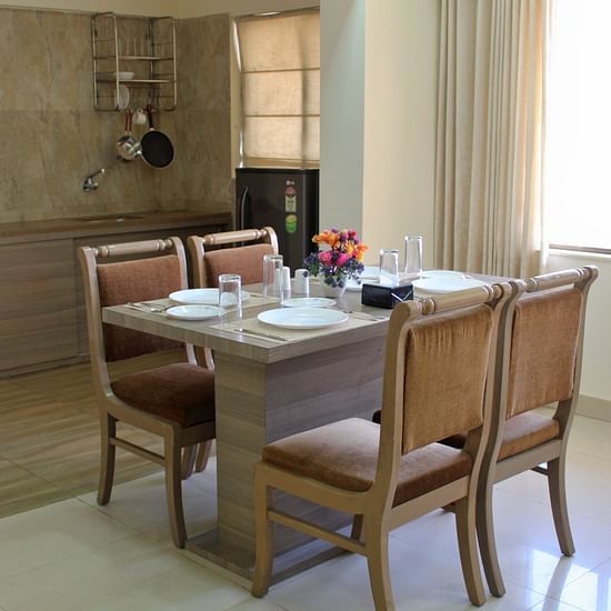 A dining area featuring a table anf chairs - Maxxvalue Apartment Marol