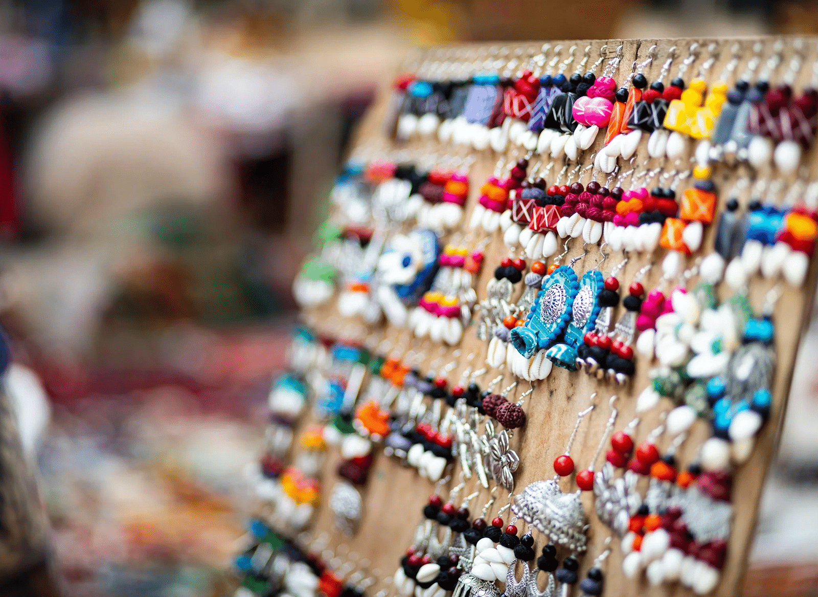 A potrait image of colourful earrings arranged nicely in a shop.