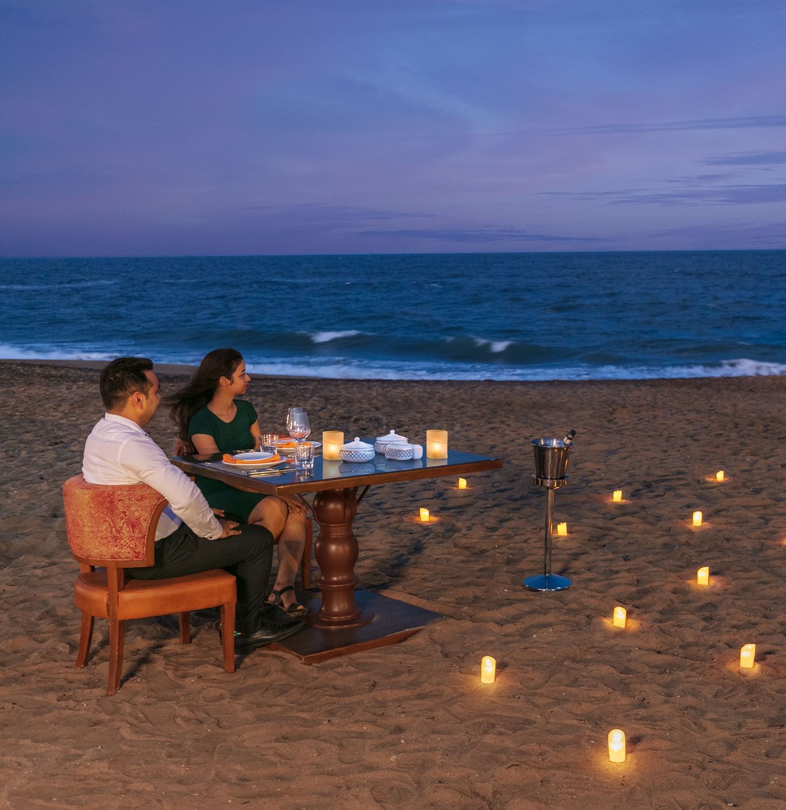 A romantic candlelight dinner setup on a pristine sandy beach – Kaldan Samudra Palace, one of the top 5 Star Restaurants in Mahabalipuram ECR, offering an unforgettable dining experience by the sea