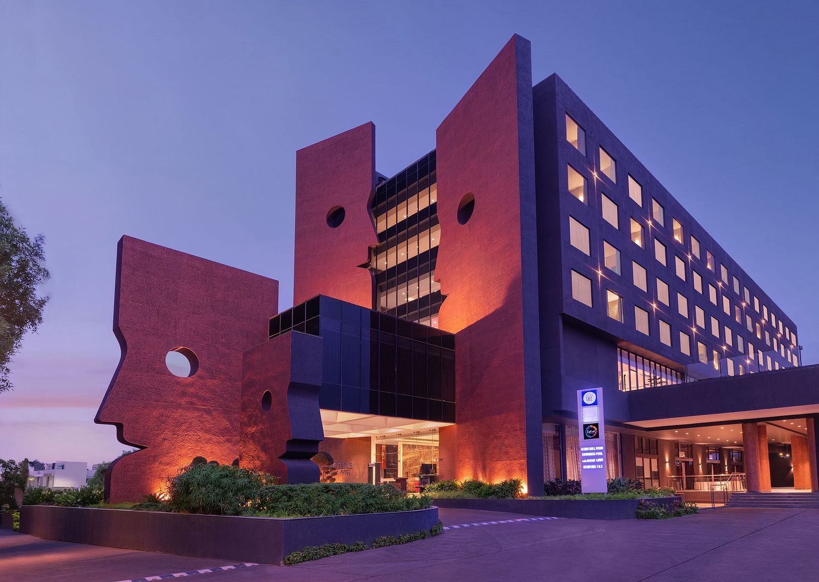 Far out view of Essentia Luxury Hotel, Indore during blue hour with the lights on.