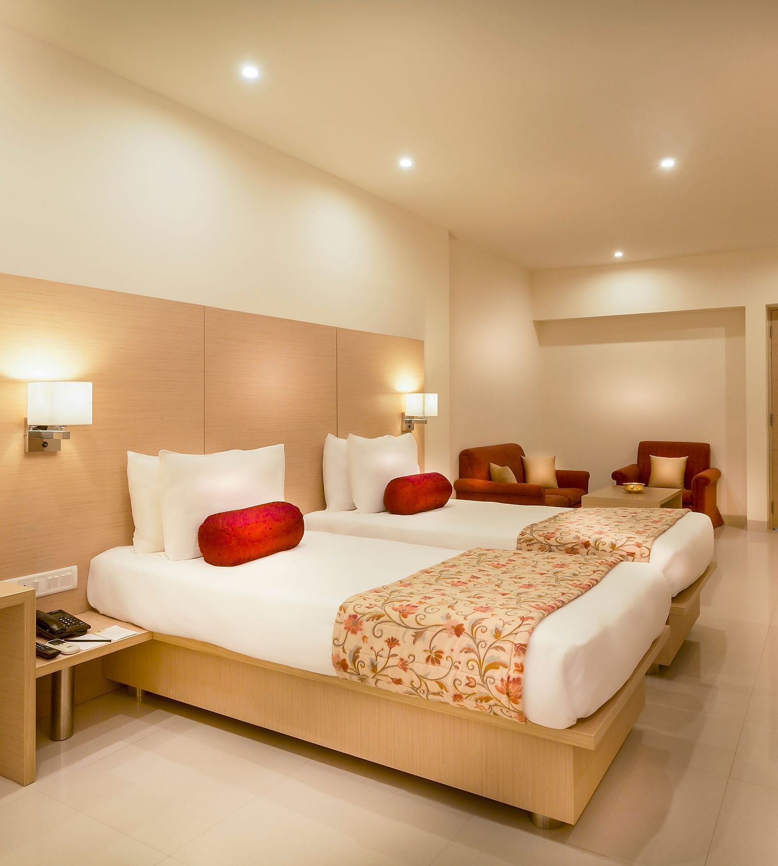 An image of a king size bed with a work desk and TV of a Suite at Regency Tiruttani by GRT Hotels.