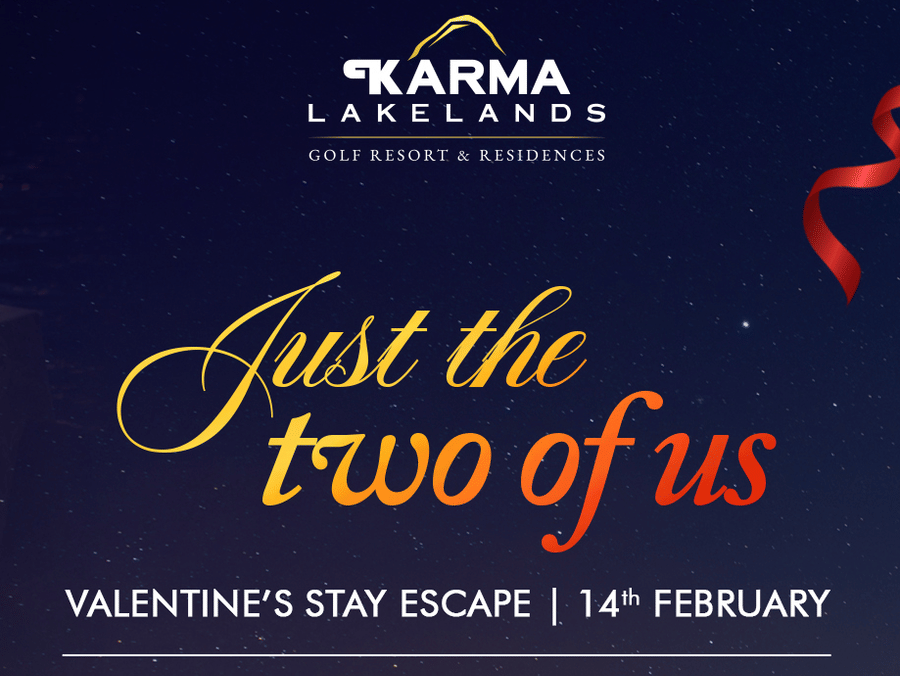 A romantic candlelit dinner setup by the water at Karma Lakelands with a table for 2, featuring flowers, glasses, and candles, promoting the Valentine’s Stay Escape on 14th February with perks including welcome drink, breakfast, couple spa, boat ride, and 