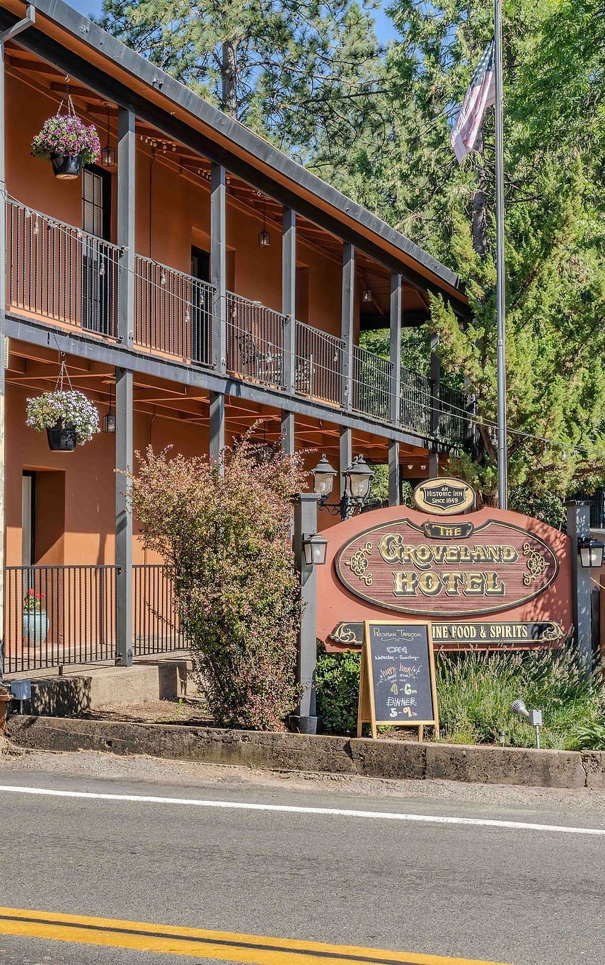 Exterior of a cabin at The Groveland Hotel during the day with the hotel's signage in view.