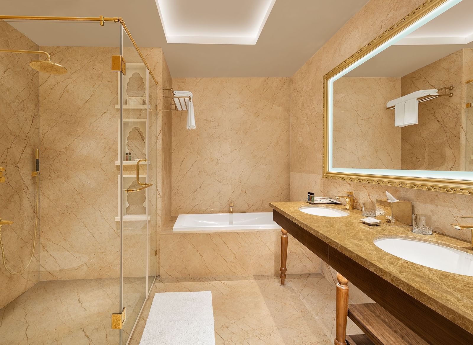 Marble bathroom featuring a walk-in shower and premium toiletries on the vanity - Kaldan Samudhra