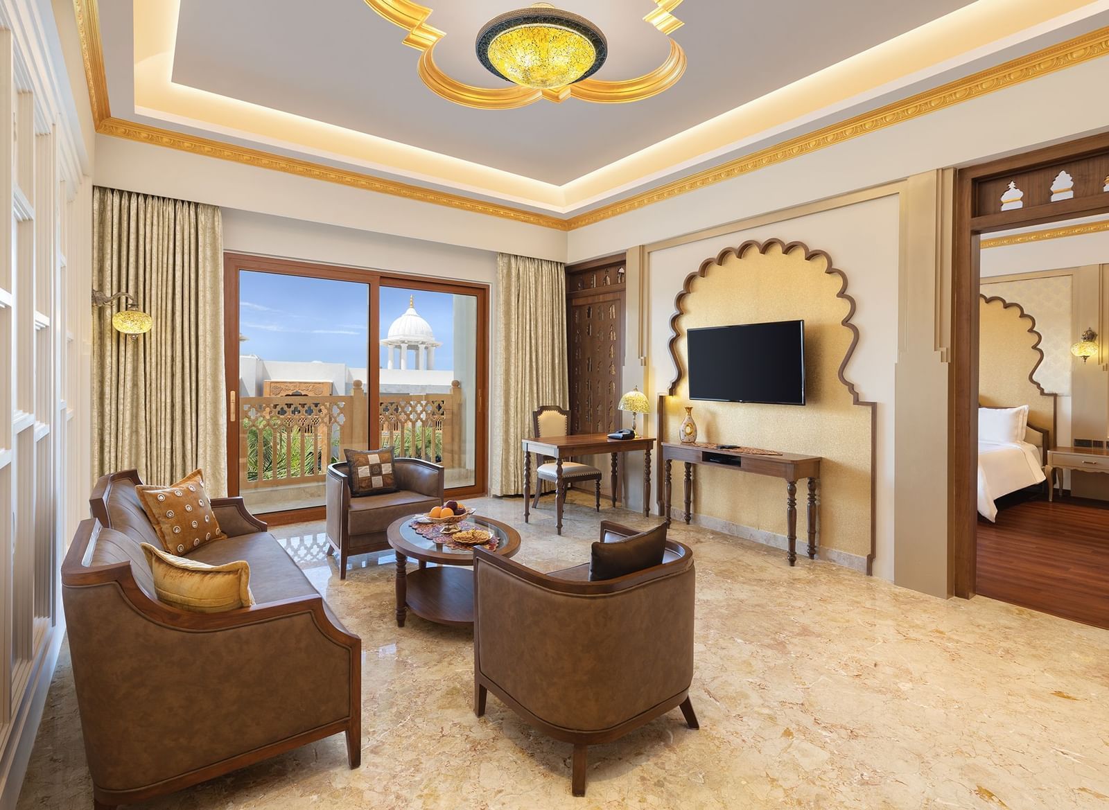A seating area in our suite in Mahabalipuram with large windows, neutral tones, and cosy armchairs - Kaldan Samudhra