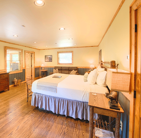 a beautiful room with a flat screen television and a wooden shelf placed opposite to a double bed - Historic Tapoco Lodge