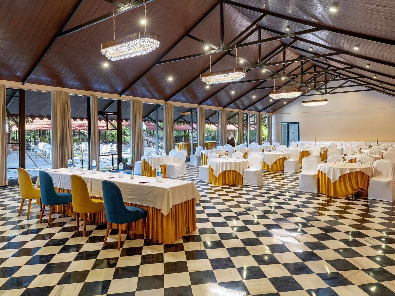 corner view of the banquet hall in udaipur with a high ceiling and properly arranged chairs and tables