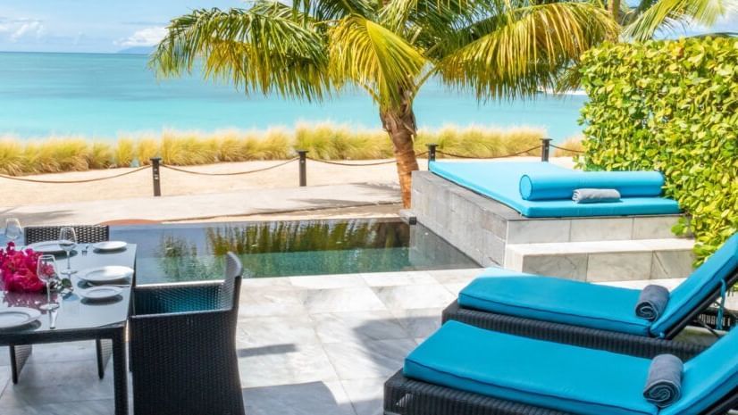 A small private pool facing the beach with ample lounge space and private dining area