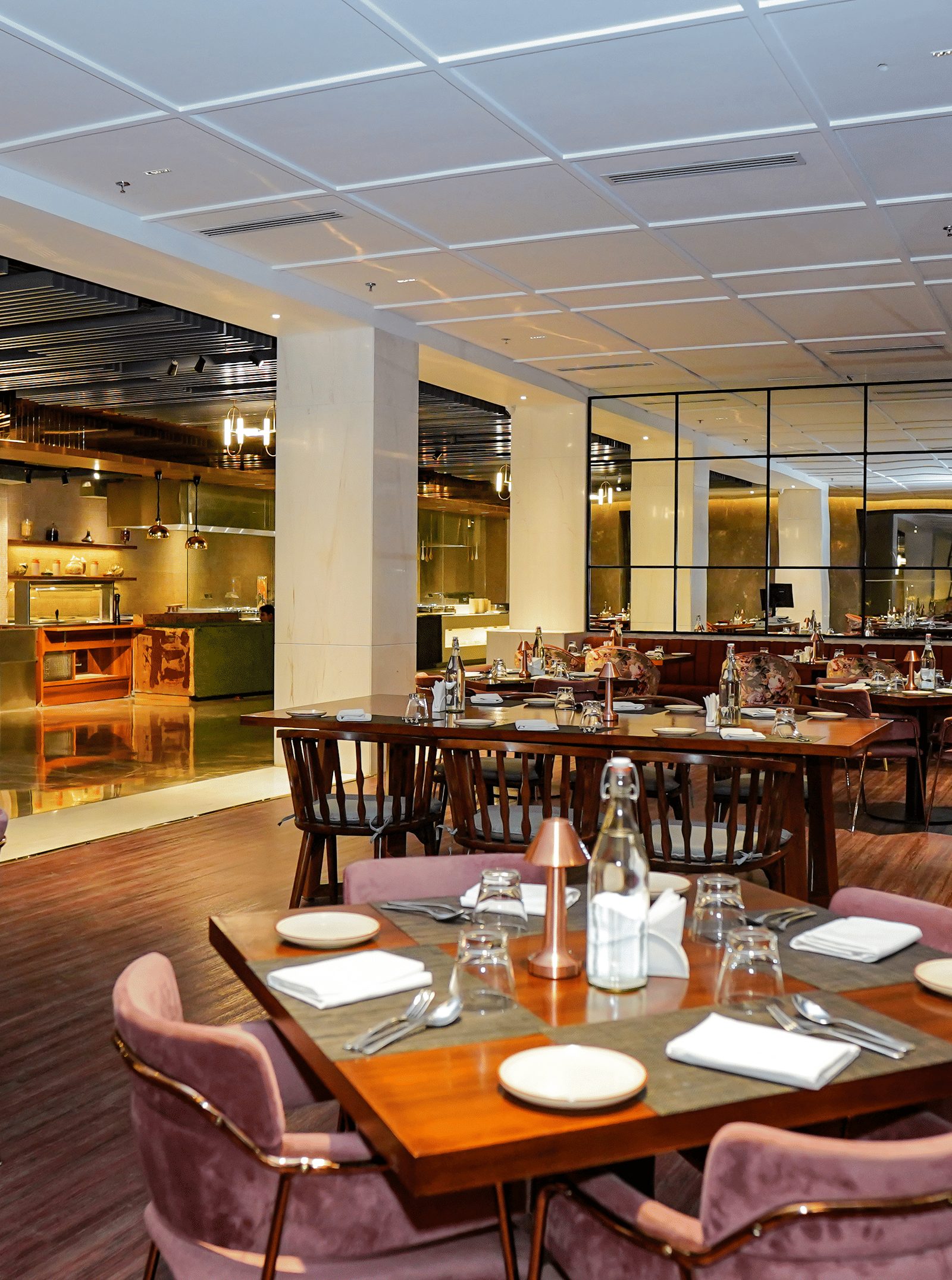 A bright, spacious fine dining restaurant with plush purple chairs and a high chair at Pushkara Resort & Spa.