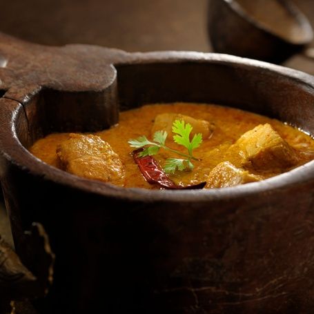 Kerala Fish Curry in a traditional wooden bowl.