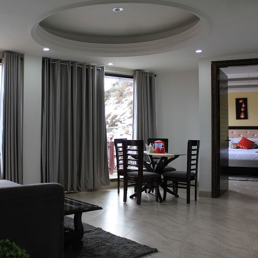 A full view of the living area with huge glass windows whose curtains are drawn wide open - Silverpine Apartments & Homestay, Mehli
